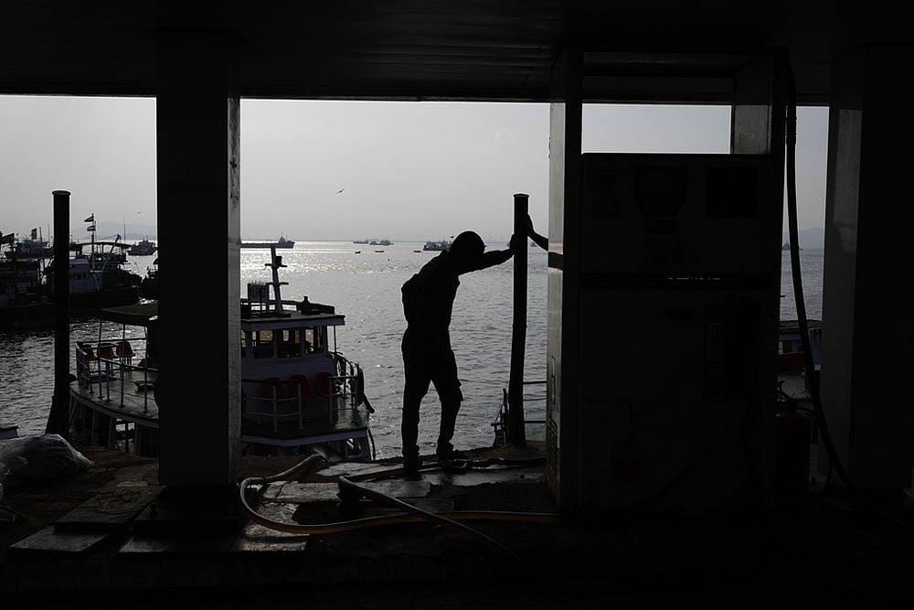 A fisherman stands next to a cooperative diesel pump that is shut due to rising bulk fuel prices at Bhaucha Dhakka in Mumbai, India. - Photo: AP/Rafiq Maqbool