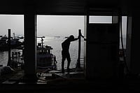 Photo: AP/Rafiq Maqbool : A fisherman stands next to a cooperative diesel pump that is shut due to rising bulk fuel prices at Bhaucha Dhakka in Mumbai, India.