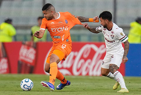 Rommell Ibarra of Venezuela's Deportivo La Guaira, left, and Lucho Acosta of Brazil's Fluminense vie for the ball during a Copa Libertadores Group C soccer match in Caracas, Venezuela.