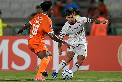 Yeferson Soteldo of Brazil's Fluminense attempts to get around Yackson Rivas of Venezuela's Deportivo La Guaira during a Copa Libertadores Group C soccer match in Caracas, Venezuela.