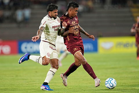 Luis Sandoval of Colombia's Deportes Tolima, right, is challenged by Cain Fara of Peru's Universitario during a Copa Libertadores Group B soccer match in Ibague, Colombia.