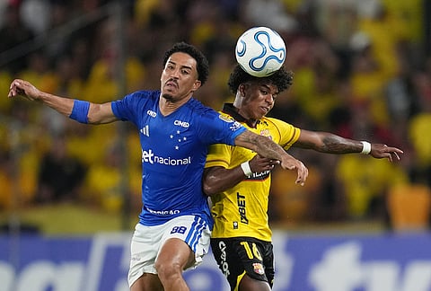 Christian of Brazil's Cruzeiro, left, fights the ball with Luis Cano of Ecuador's Barcelona during a Copa Libertadores soccer Group D match in Guayaquil, Ecuador.