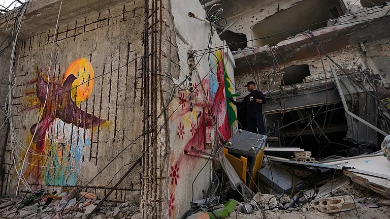 A graffiti artist paints on the wall of a building damaged in an Israeli airstrike in the southern port city of Tyre, Lebanon. - Photo: AP/Mohammed Zaatari