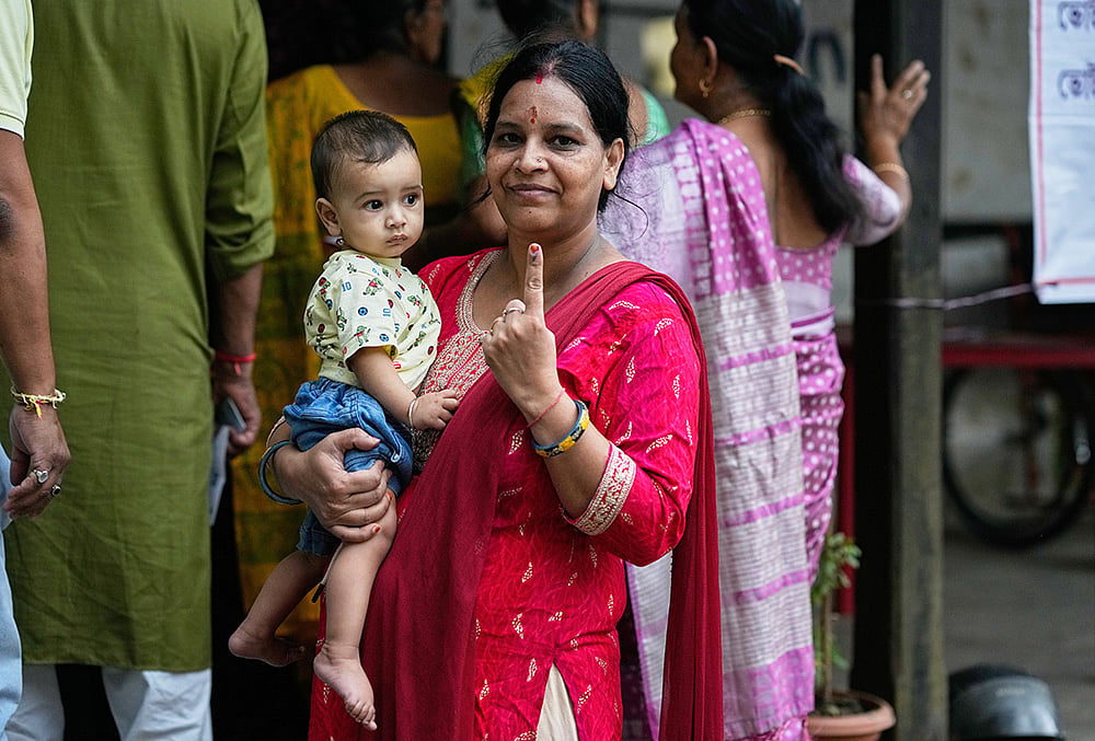 A woman shows the indelible ink mark on her index finger after casting her vote at a polling center during the state election in Guwahati. - | Photo: AP/Anupam Nath