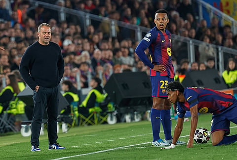 Barcelona's head coach Hansi Flick, left, Barcelona's Jules Kounde, Barcelona's Lamine Yamal during the Champions League quarterfinal first leg soccer match between Barcelona and Atletico Madrid in Barcelona, Spain.