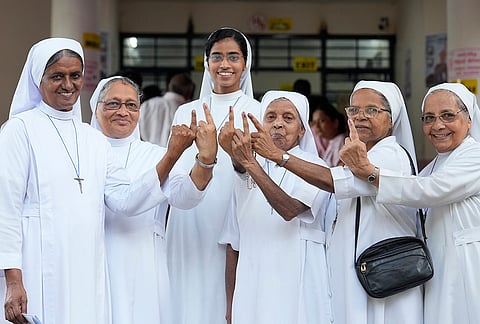 Nuns pose for photographs with their ink-marked fingers after casting votes during the Puducherry Assembly elections, in Puducherry.
