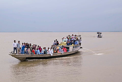 People cross the Brahmaputra river on a boat to casts their votes in the Assam Assembly elections, in Darrang.