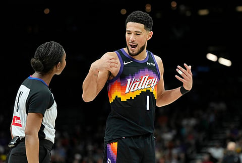 Phoenix Suns guard Devin Booker (1) talks with referee Danielle Scott during the second half of an NBA basketball game against the Dallas Mavericks, in Phoenix.