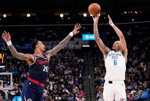 Oklahoma City Thunder forward Jaylin Williams, right, shoots as Los Angeles Clippers forward John Collins defends during the first half of an NBA basketball game in Inglewood, California.