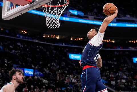 Los Angeles Clippers guard Jordan Miller, right, dunks as Oklahoma City Thunder center Chet Holmgren defends during the second half of an NBA basketball game in Inglewood, California.