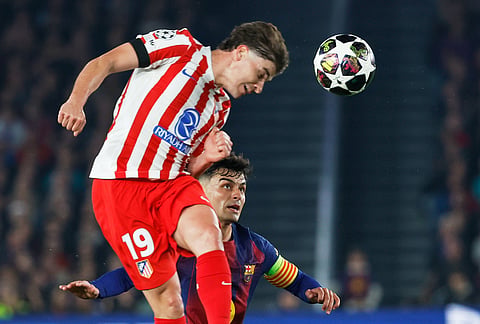 Atletico Madrid's Julian Alvarez heads the ball ahead of Barcelona's Pedri during the Champions League quarterfinal first leg soccer match between Barcelona and Atletico Madrid in Barcelona, Spain.