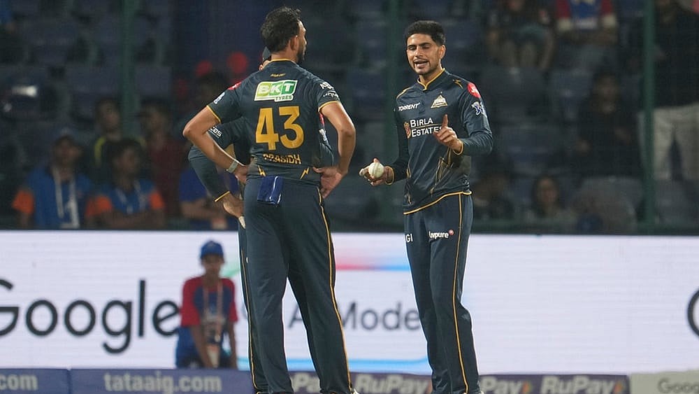 Gujarat Titans' captain Shubman Gill, right, talks to his team bowler Prasidh Krishna during the Indian Premier League cricket match between Delhi Capitals and Gujarat Titans in New Delhi. - | Photo: AP/Manish Swarup