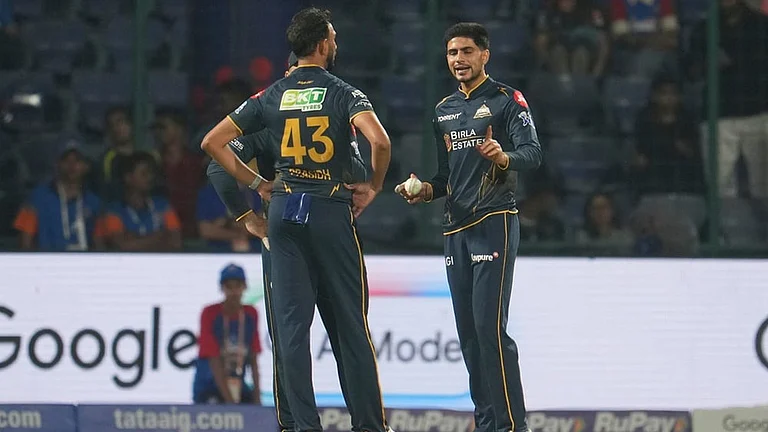 Gujarat Titans' captain Shubman Gill, right, talks to his team bowler Prasidh Krishna during the Indian Premier League cricket match between Delhi Capitals and Gujarat Titans in New Delhi. - | Photo: AP/Manish Swarup
