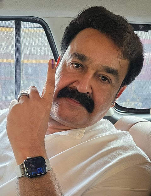 Actor Mohanlal shows his ink-marked finger after casting vote during the state Assembly elections, in Thiruvananthapuram. 
