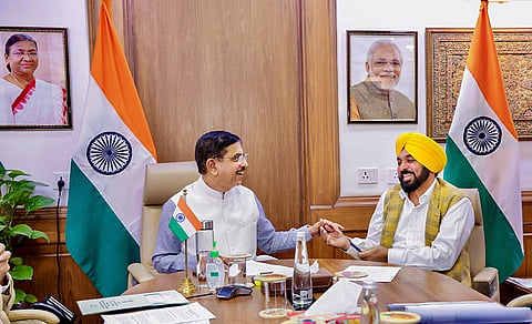 Union Minister for Consumer Affairs, Food and Public Distribution Pralhad Joshi, left, interacts with Punjab Chief Minister Bhagwant Mann during a meeting, in New Delhi. 