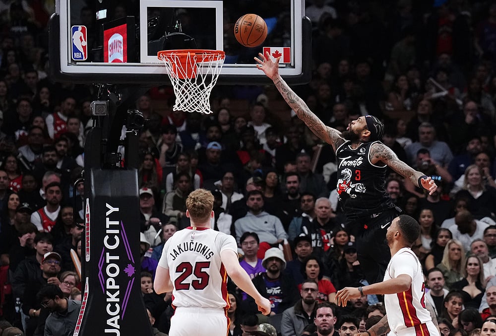 Toronto Raptors' Brandon Ingram (3) scores as Miami Heat's Kasparas Jakucionis (25) and Norman Powell (24) look on during the second half of an NBA basketball game in Toronto. - | Photo: Nathan Denette/The Canadian Press via AP