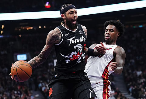Toronto Raptors' Brandon Ingram (3) protects the ball from Miami Heat's Davion Mitchell (45) during the first half of an NBA basketball game in Toronto.