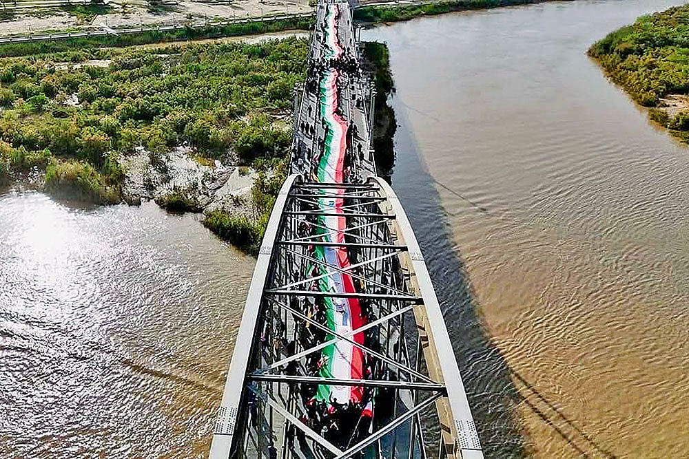 ‘We Defend Iran With our Lives’: The people of Ahvaz form a human chain on the city’s old bridge standing firm against any attack by Trump. - | Courtesy: X