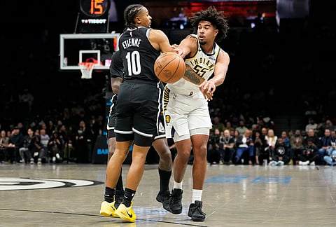 Indiana Pacers guard Ethan Thompson (55) passes the ball away past Brooklyn Nets guard Tyson Etienne (10) during the first half of an NBA basketball game, in New York.