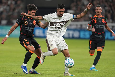 Ignacio Vazquez of Argentina's Platense, center, protects the ball from Yuri Alberto of Brazil's Corinthians during a Copa Libertadores Group E soccer match in Buenos Aires, Argentina.