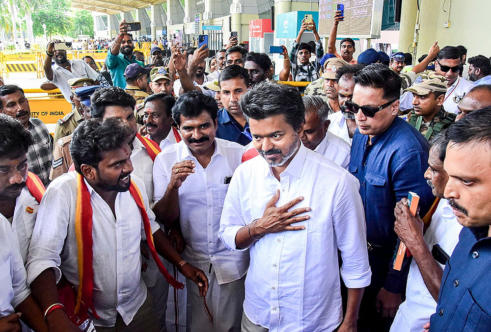 Actor and Tamilaga Vettri Kazhagam (TVK) chief Vijay being greeted by supporters upon his arrival at the airport, before heading to Karaikudi for an election campaign ahead of the Tamil Nadu Assembly polls, in Madurai. - | Photo: PTI 
