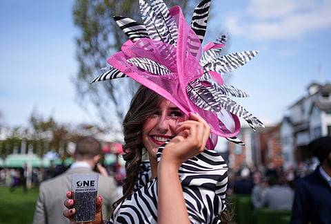 A racegoer poses as she attends Ladies Day, the second day of the Grand National Horse Racing festival, at Aintree racecourse, near Liverpool, England.