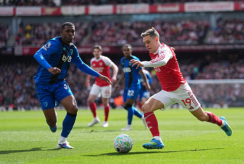 Arsenal's Leandro Trossard in action in front of Bournemouth's Adrien Truffert during the Premier League soccer match between Arsenal and Bournemouth in London, England.