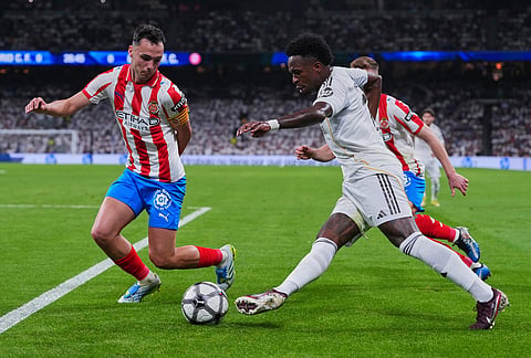 Real Madrid's Vinicius Junior, right, duels for the balls with Girona's Arnau Martinez during a Spanish La Liga soccer match between Real Madrid and Girona in Madrid, Spain.