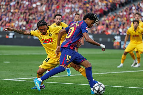 Barcelona's Lamine Yamal, centre, and Espanyol's Tyrhys Dolan challenge for the ball during the Spanish La Liga soccer match between Barcelona and Espanyol in Barcelona, Spain.