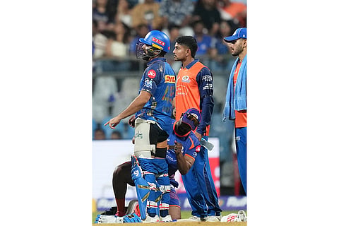 A physiotherapist attends Mumbai Indians' Rohit Sharma as he developed a strain in his leg during the Indian Premier League cricket match between Mumbai Indians and Royal Challengers Bengaluru, in Mumbai, India