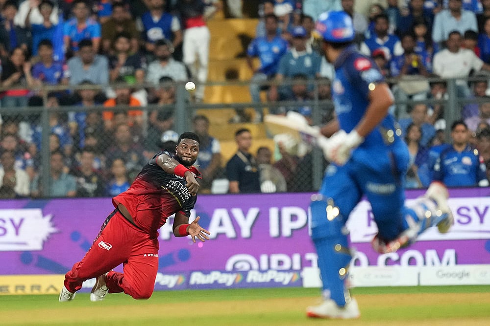 Royal Challengers Bengaluru's Romario Shepherd throws a ball during the Indian Premier League cricket match between Mumbai Indians and Royal Challengers Bengaluru, in Mumbai , India. - | Photo: AP/Rafiq Maqbool