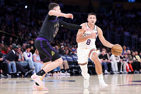 Phoenix Suns guard Grayson Allen (8) drives against Los Angeles Lakers forward Jake LaRavia, left, during the first half of an NBA basketball game in Los Angeles.