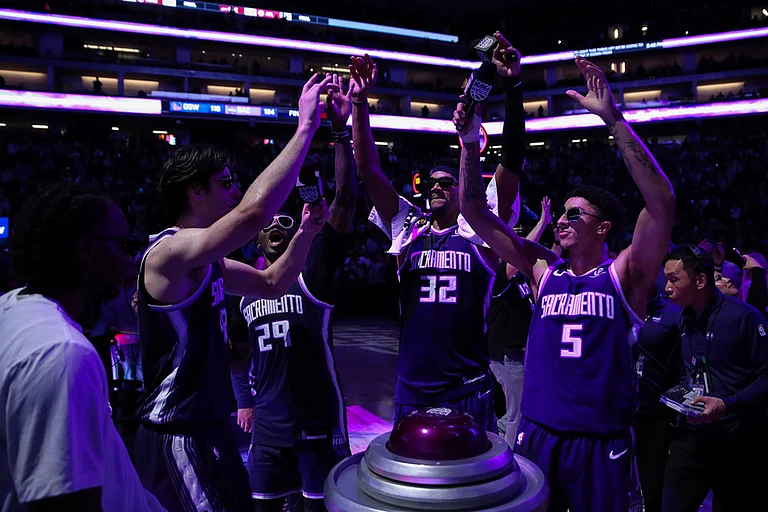Sacramento Kings center Maxime Raynaud (42), Daeqwon Plowden (29), Dylan Cardwell (32) and Nique Clifford (5) light the beam after the Kings victory over the Golden State Warriors in an NBA basketball game in Sacramento, Calif. - | Photo: AP/Scott Marshall