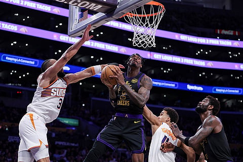 Los Angeles Lakers forward Jarred Vanderbilt (2) draws a foul against Phoenix Suns forward Dillon Brooks, left, as forward Oso Ighodaro, second from right, and Los Angeles Lakers center Deandre Ayton, right, watch during the second half of an NBA basketball game in Los Angeles.