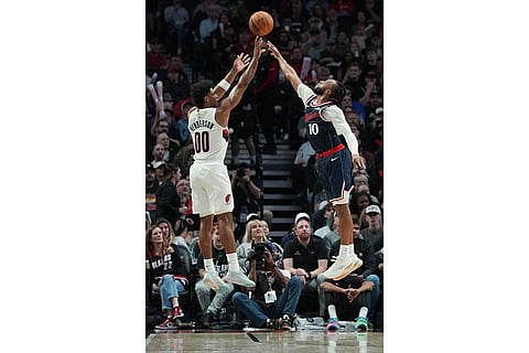 Portland Trail Blazers guard Scoot Henderson (00) shoots past Los Angeles Clippers guard Darius Garland (10) during the second half of an NBA basketball game in Portland, Ore.