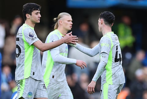Manchester City's Abdukodir Khusanov, left, and Phil Foden shake hands after the Premier League soccer match between Chelsea and Manchester City in London.
