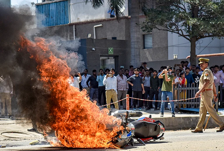 Flames billow as a police bike is set ablaze by factory workers during a protest demanding a hike in wages, in Noida, Gautam Buddh Nagar district, Uttar Pradesh. The protest carried incidents of arson, vandalism and stone-pelting reported from Phase-2 and Sector 60 areas, police said. - | Photo: PTI