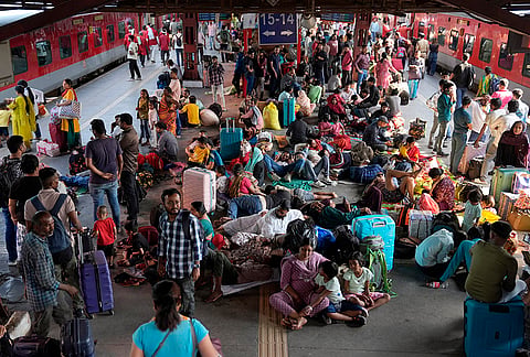 Large crowds occupy the New Delhi Railway Station platform, as passengers sit, rest, and wait amid a heavy rush of many going back to their native states due to the LPG crisis. 