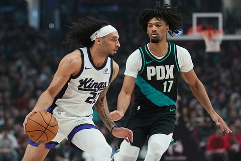 Sacramento Kings guard Devin Carter (22) looks to get past Portland Trail Blazers guard Shaedon Sharpe (17) during the first half of an NBA basketball game in Portland, Ore.