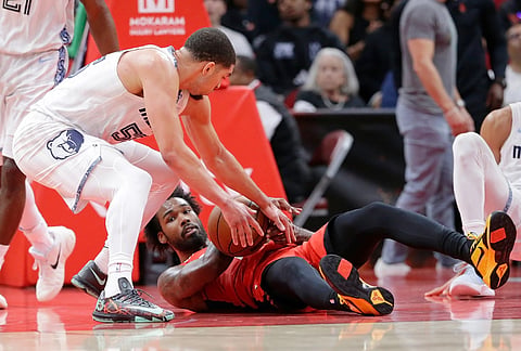 Memphis Grizzlies guard Lucas Williamson, left, reaches to strip the ball from Houston Rockets forward Tari Eason, right, after falling during the first half of an NBA basketball game in Houston. 