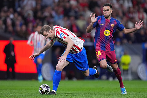 Atletico Madrid's Alexander Sorloth, left, and Barcelona's Eric Garcia challenge for the ball during the Champions League quarterfinal second leg soccer match between Atletico Madrid and Barcelona in Madrid, Spain.