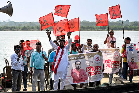 CPI (M) candidate for Santipur constituency, Soumen Mahato waves to the gathering as he takes a boat ride during an election campaign ahead of the West Bengal Assembly Election, in Hooghly district.