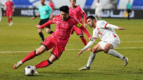 South Korea's Son Heung-min, left, controls the ball against Jordan's Mohannad Abu Tana during a World Cup qualifying soccer match in Suwon, South Korea, Tuesday, March 25, 2025.