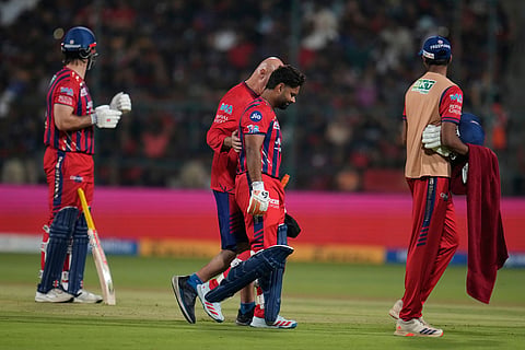 Lucknow Super Giants' captain Rishabh Pant, centre, leaves the field after retired hurt during the Indian Premier League cricket match between Royal Challengers Bengaluru and Lucknow Super Giants in Bengaluru, India.
