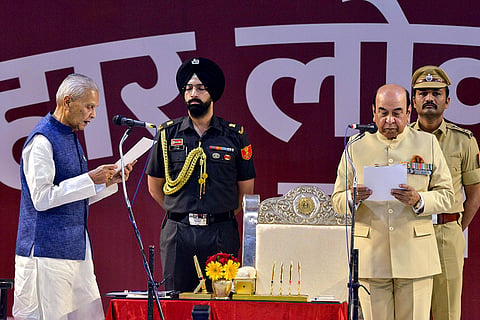Bihar Governor Syed Ata Hasnain, right, administers the oath of office to JD(U) leader Bijendra Prasad Yadav, left, during his swearing-in ceremony as member of the Council of Ministers, at Lok Bhawan, in Patna.