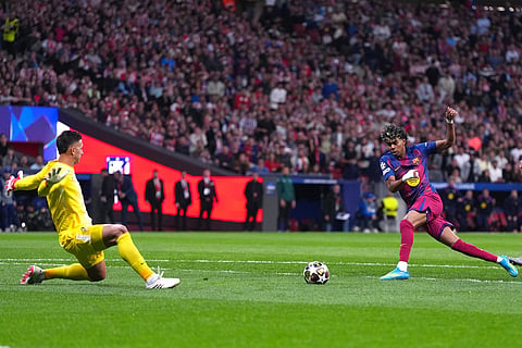 Barcelona's Lamine Yamal, right, scores the opening goal during the Champions League quarterfinal second leg soccer match between Atletico Madrid and Barcelona in Madrid, Spain.