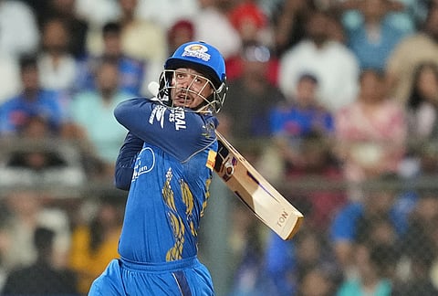Mumbai Indians' wicketkeeper Quinton de Kock hits a boundary during the Indian Premier League cricket match between Mumbai Indians and Punjab Kings in Mumbai.