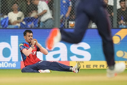 Punjab Kings' Yuzvendra Chahal takes the catch to dismiss Mumbai Indians' Suryakumar Yadav during the Indian Premier League cricket match between Mumbai Indians and Punjab Kings in Mumbai.