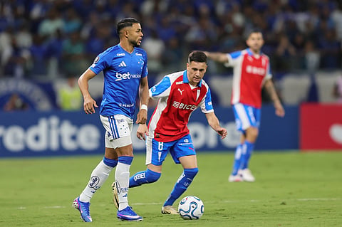 Wanderson of Brazil's Cruzeiro, left, goes with the ball followed by Fernando Zuqui of Chile's Universidad Catolica during a Copa Libertadores Group D soccer match in Belo Horizonte, Brazil.