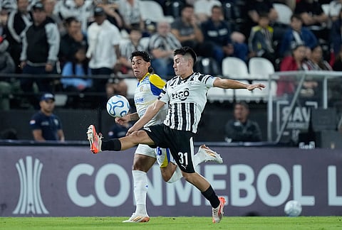 Thiago Fernandez of Paraguay's Libertad, right, and Enzo Gimenez of Argentina's Rosario Central battle for the ball during a Copa Libertadores Group H soccer match in Asuncion, Paraguay.
